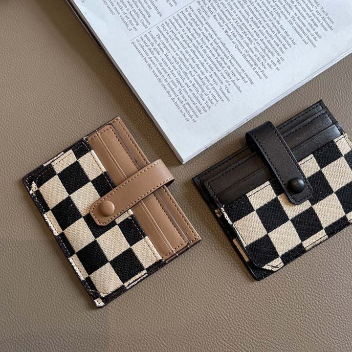 Close-up of the zipper pull on a women's plaid colorblock compact wallet, gold-tone hardware