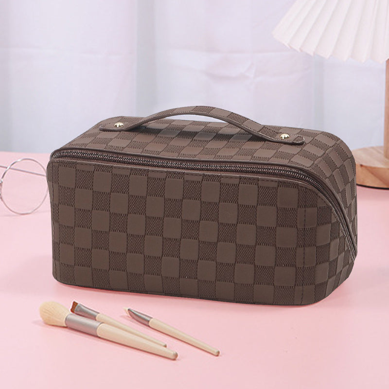 Top-down view of open plaid cosmetic bag, revealing compartments for organization.