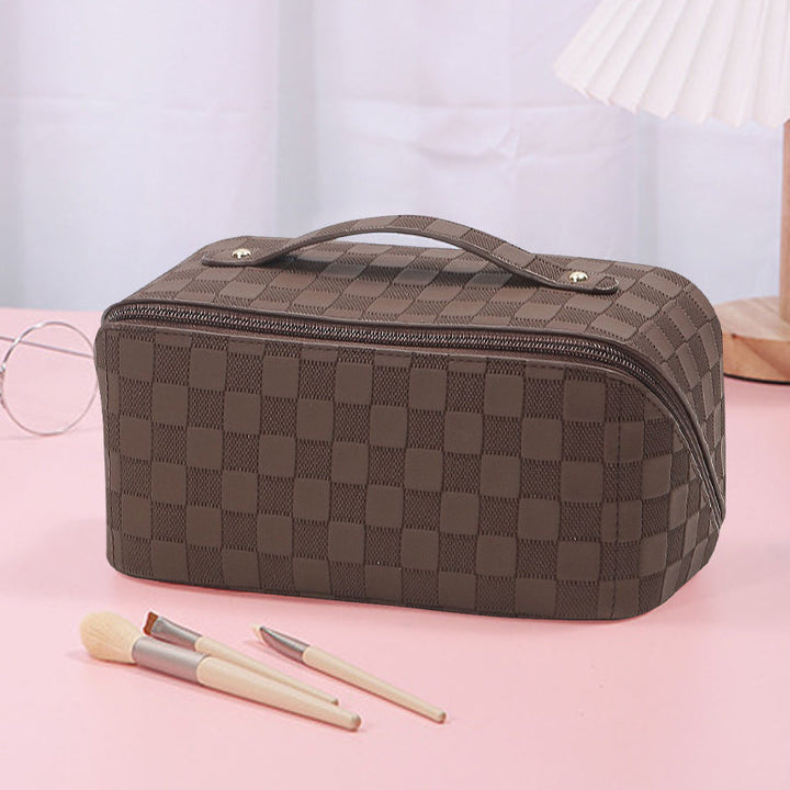 Top-down view of open plaid cosmetic bag, revealing compartments for organization.