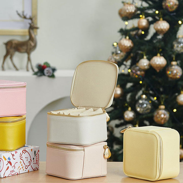 Open pink leather jewelry organizer showing velvet interior, ring rolls, and earring holders