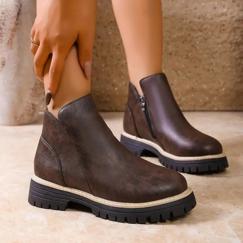 Women's premium black leather ankle boots with sturdy lug sole and side zip closure, ideal for winter.