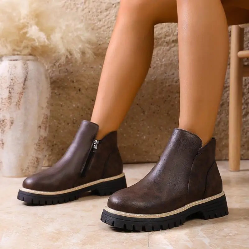 Close-up of women's dark brown leather ankle boots featuring a durable lug sole for fall fashion.