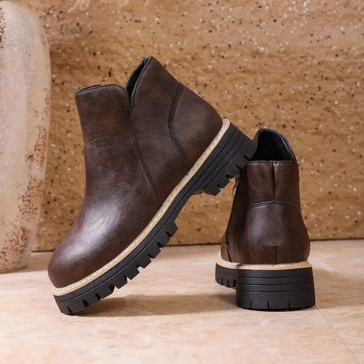 Stylish women's leather ankle boots with a prominent lug sole, perfect for comfortable winter wear.