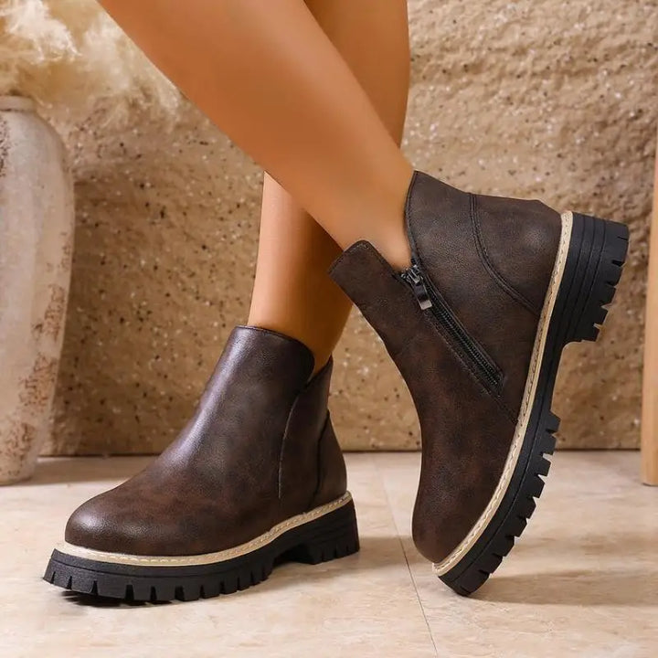 Front view of women's classic black leather ankle boots with a robust lug sole, suitable for all-day wear.