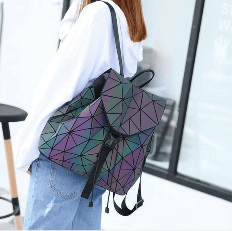 Modern women's faux leather backpack, geometric and reflective, showing its vibrant color-changing effect.