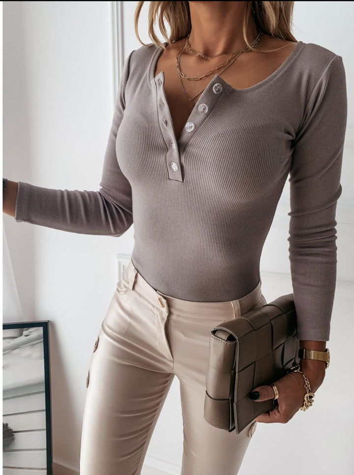 Trendy women's long sleeve ribbed top, featuring a functional button front. Perfect for layering or stand-alone wear.