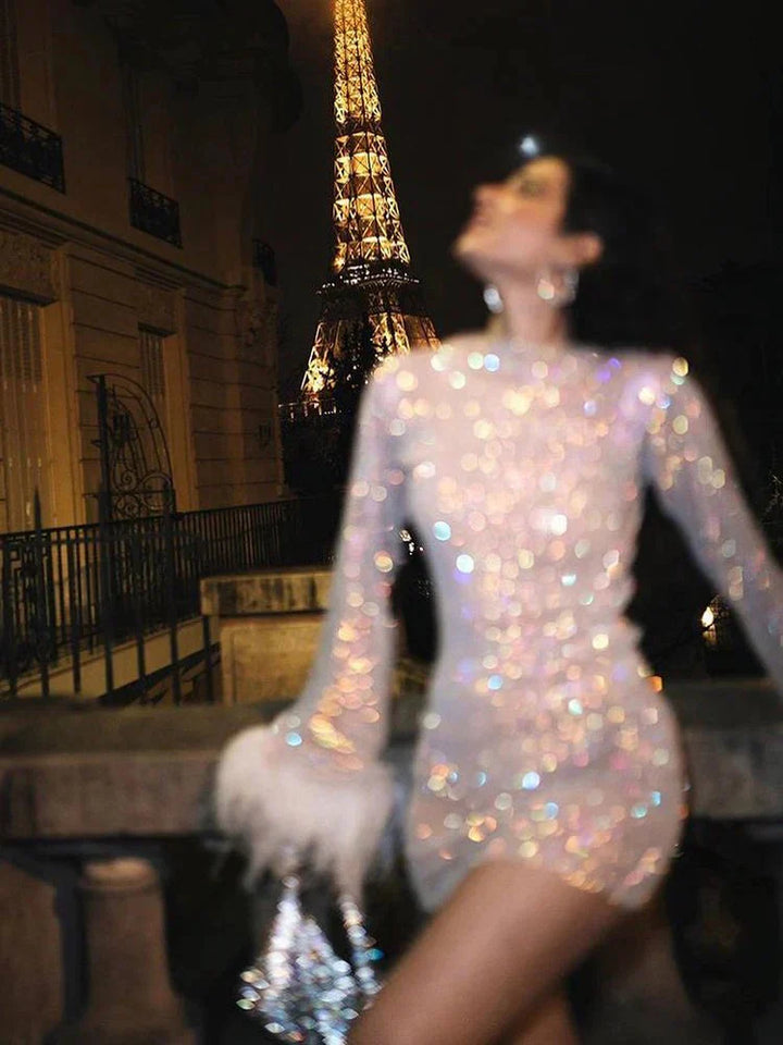 Stunning women's sequin mini dress. Sheer sleeves, feather trim, round neck. Ideal cocktail wear.