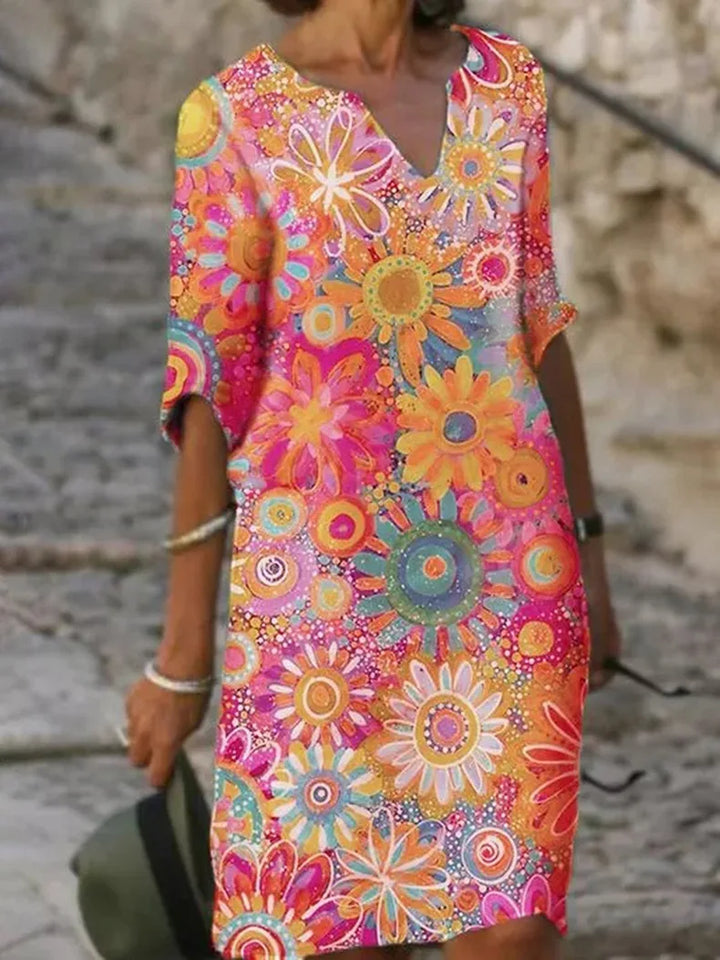 Front view of a chic women's sleeveless summer dress featuring a vibrant floral print and flowy design.