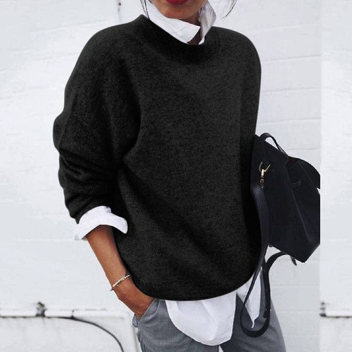 Close-up of the textured soft knit fabric of a women's round neck pullover sweater.