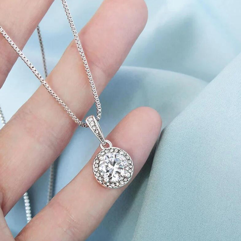 Close-up of sparkling round soulmate pendant necklace for women, silver jewelry gift.