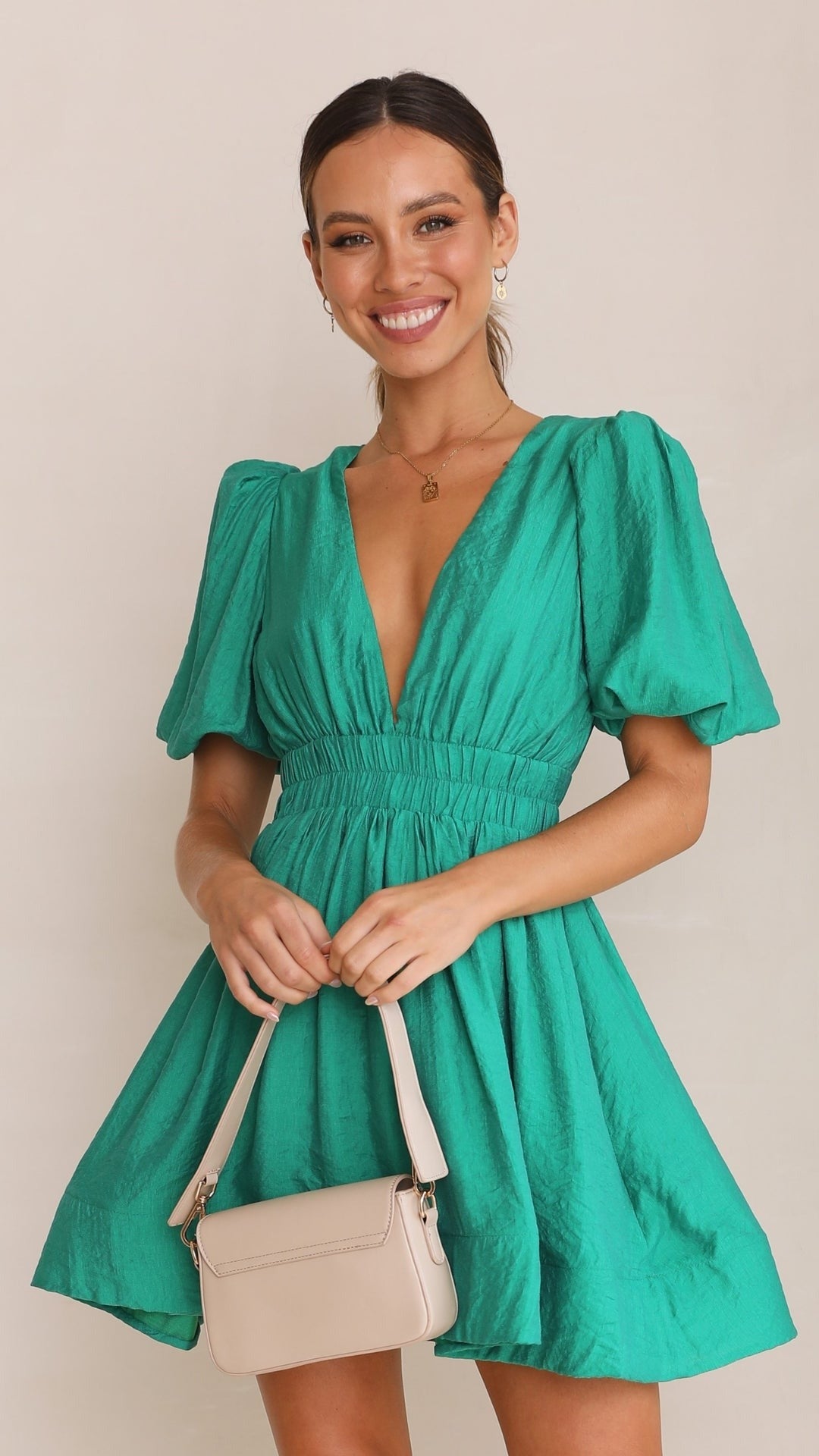 Full shot of a model wearing a 'Spring' puff sleeve mini dress, showcasing its flattering fit & style.