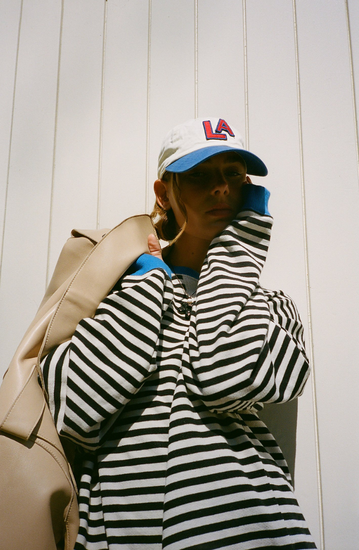 Detail of the crewneck and striped pattern on a women's spring knit sweater