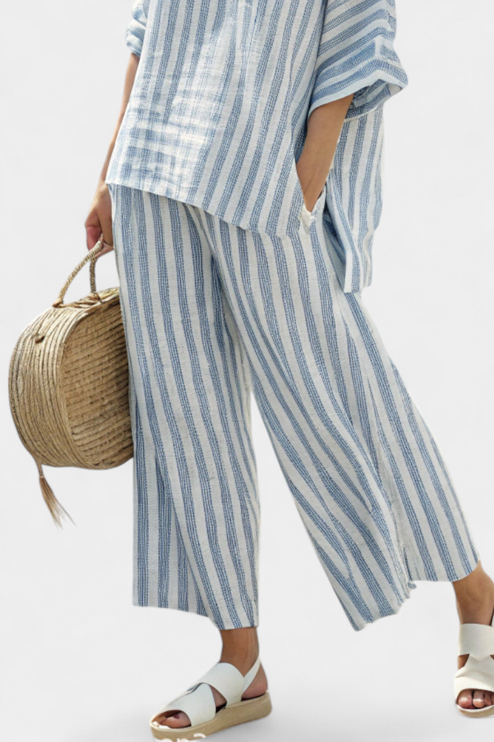 Chic women's striped coord set with oversized batwing top & wide-leg pants, offering casual elegance.