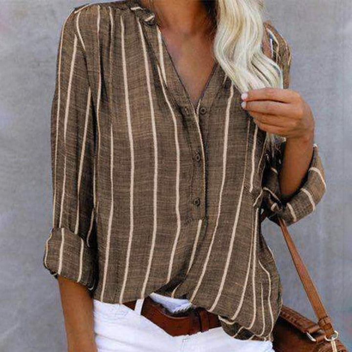 Women's striped V-neck blouse with versatile roll-tab long sleeves for casual or elegant wear.