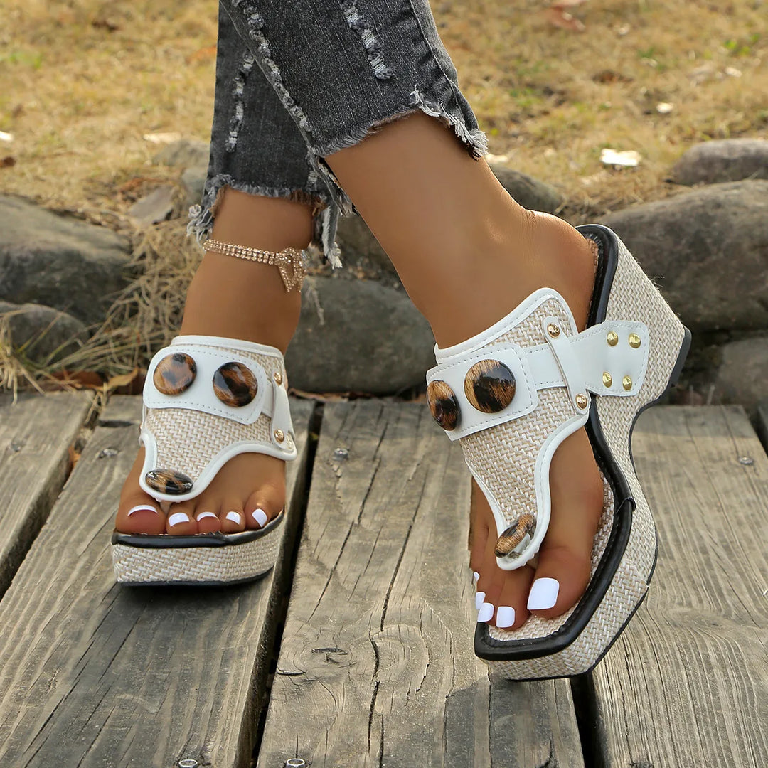 Chic women's studded platform wedge slides in black, close-up of studs, fashion footwear
