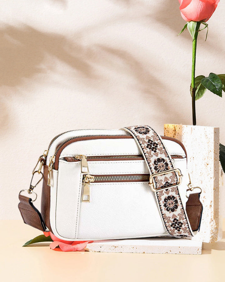 Women's black PU leather crossbody bag, shown open to reveal interior organization, zipper closure