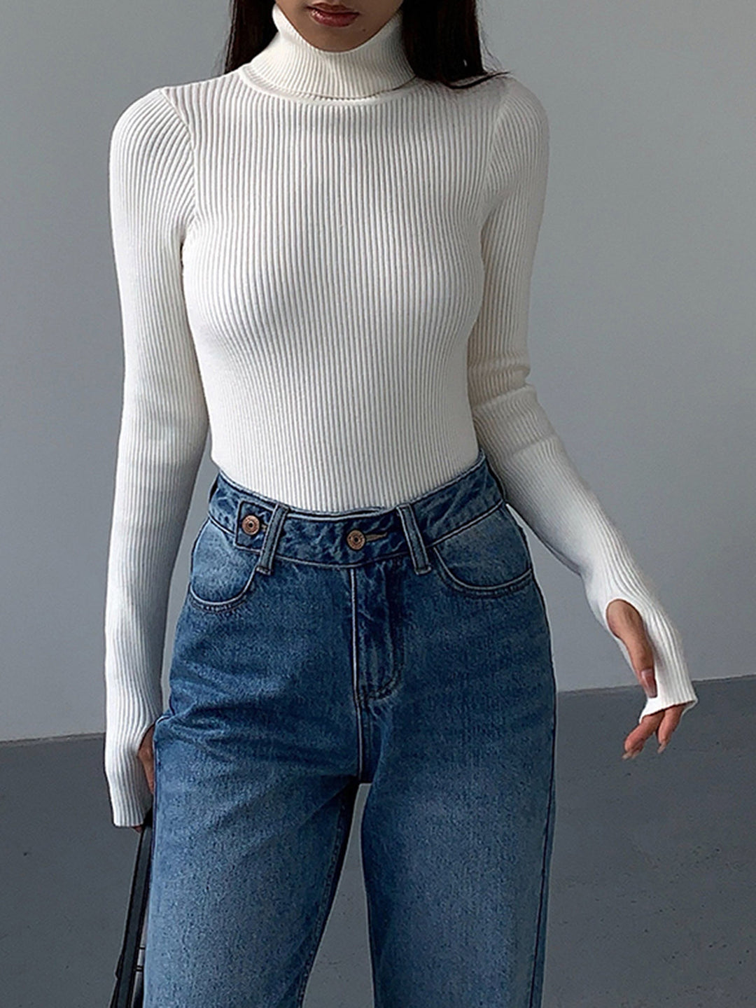Overhead shot of a meticulously folded blue ribbed turtleneck sweater, ready for display.