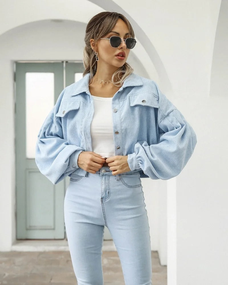 Cropped women's jacket featuring fashionable puff sleeves & light wash denim for a versatile summer look.