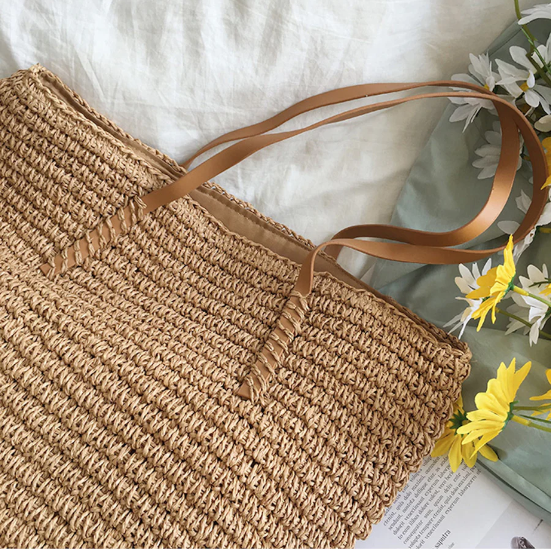 Spacious women's handbag with elegant woven design and sturdy shoulder strap.