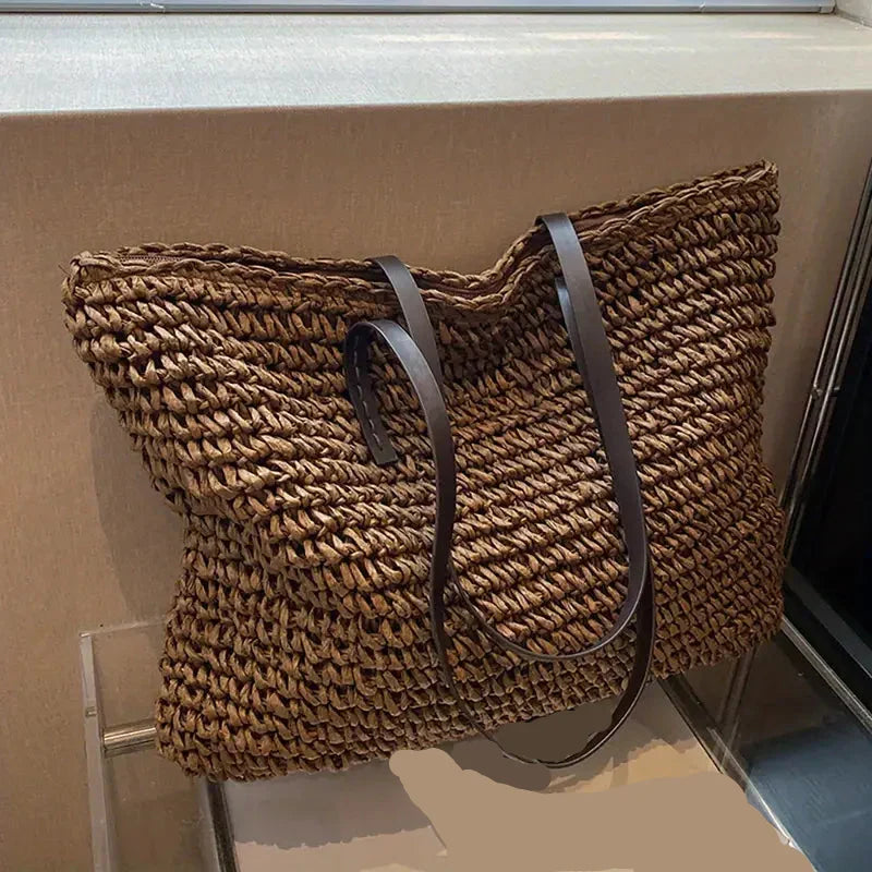 Close-up of a women's stylish woven straw tote bag, showcasing texture for beach/summer.