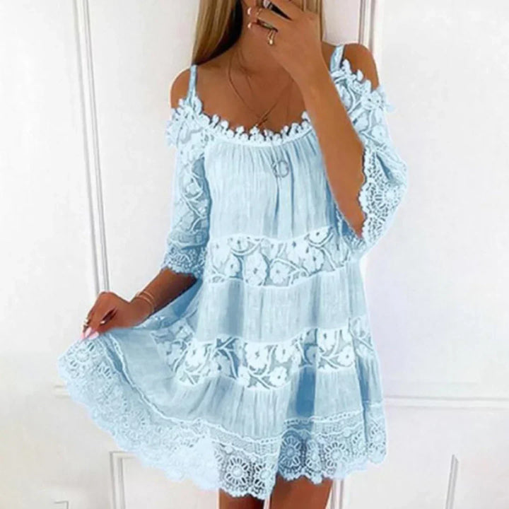 Loose fit women's mini dress with beautiful embroidered details, crochet lace, and trendy cold shoulder sleeves. Casual comfort.