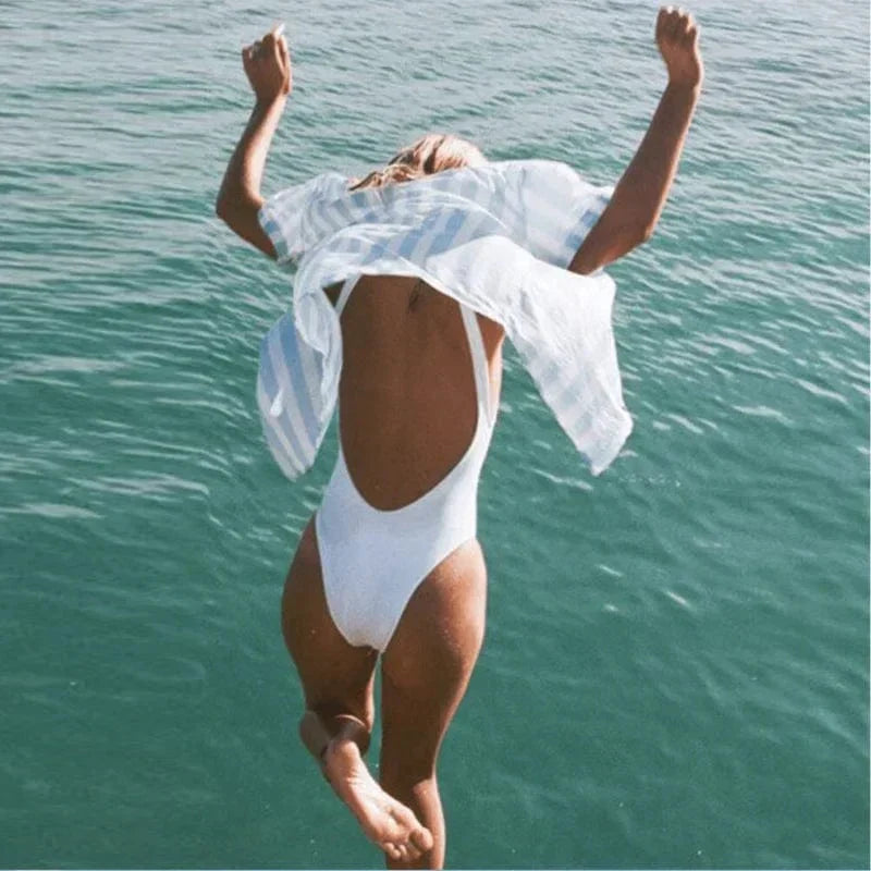 Elegant women's open-back one-piece swimsuit featuring a scoop neck, designed for comfortable swimming & beach days.