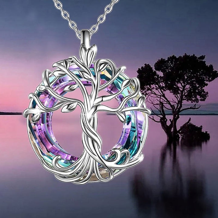 Close-up of a women's Tree of Life pendant, showcasing detailed silver-tone branches and embedded crystals.