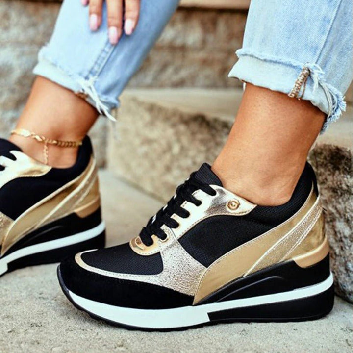 Close-up of women's gold & black fashion sneakers, non-slip, comfortable athletic style footwear
