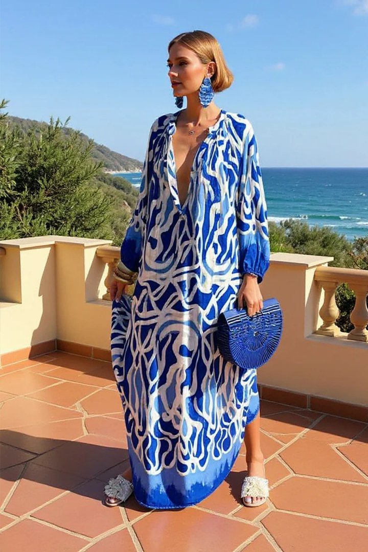 Vibrant abstract print V-neck maxi kaftan, a relaxed women's resort wear dress. Ideal for vacation outfits.