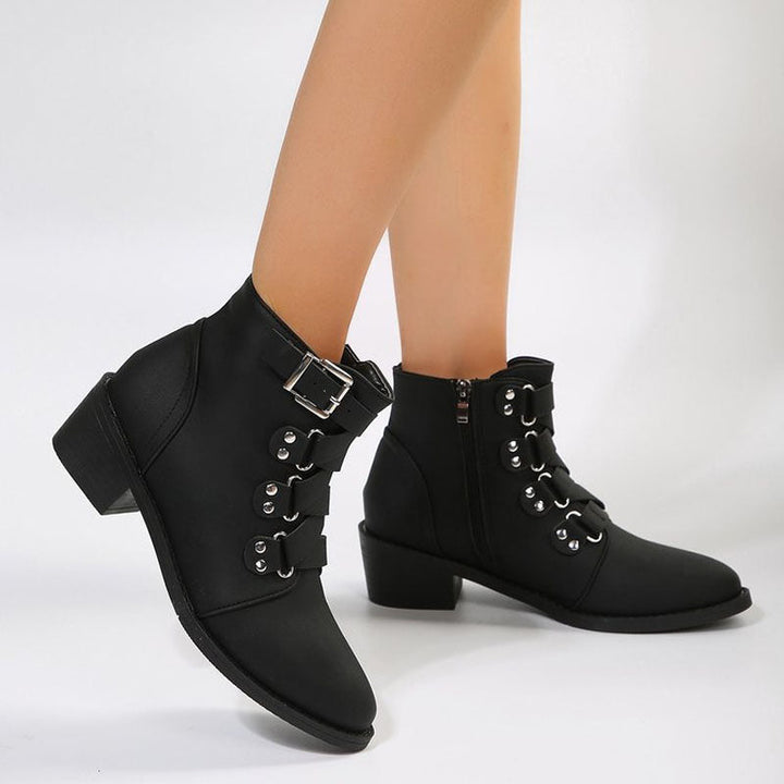 Women's chic ankle boots with vintage block heel. Elegant black leather texture.