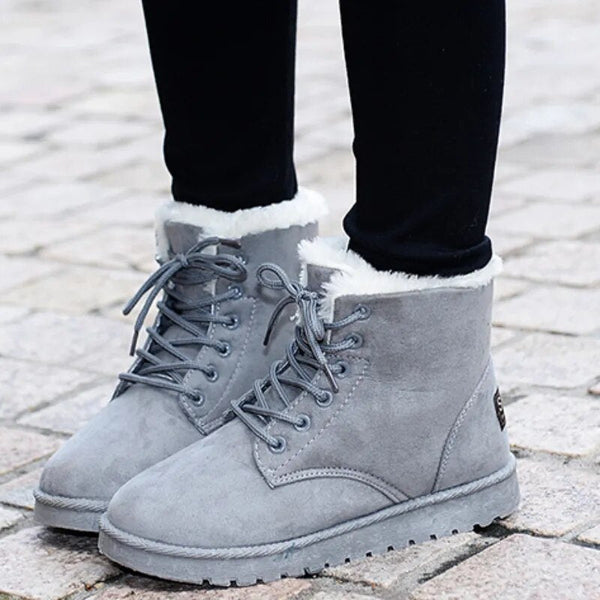 Close-up of a women's warm lace-up ankle boot showing detailed stitching and textured material.