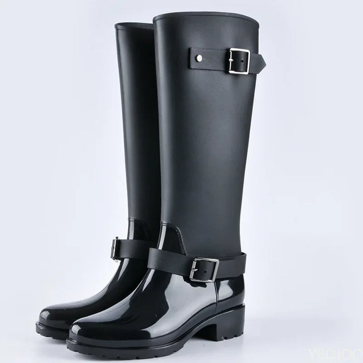 Women's waterproof knee-high rain boots with stylish buckles & practical block heels for wet weather.
