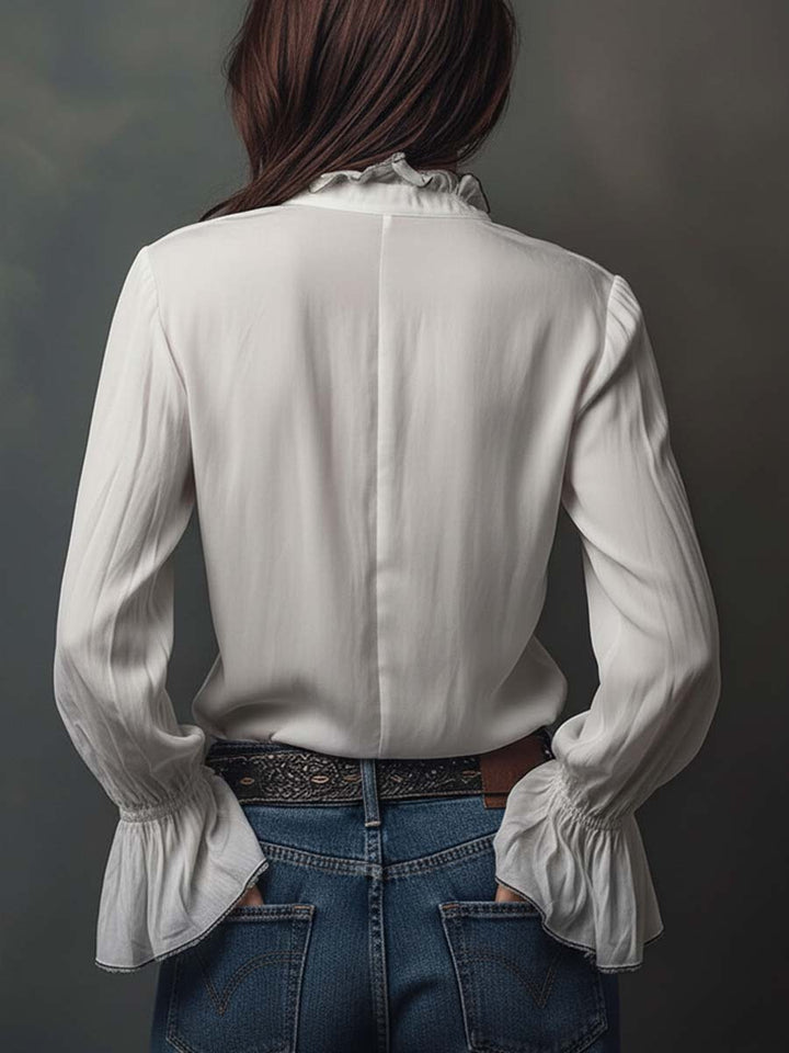Professional white women's blouse with a sophisticated zip-front and elegant bell cuffs. Tailored office wear.