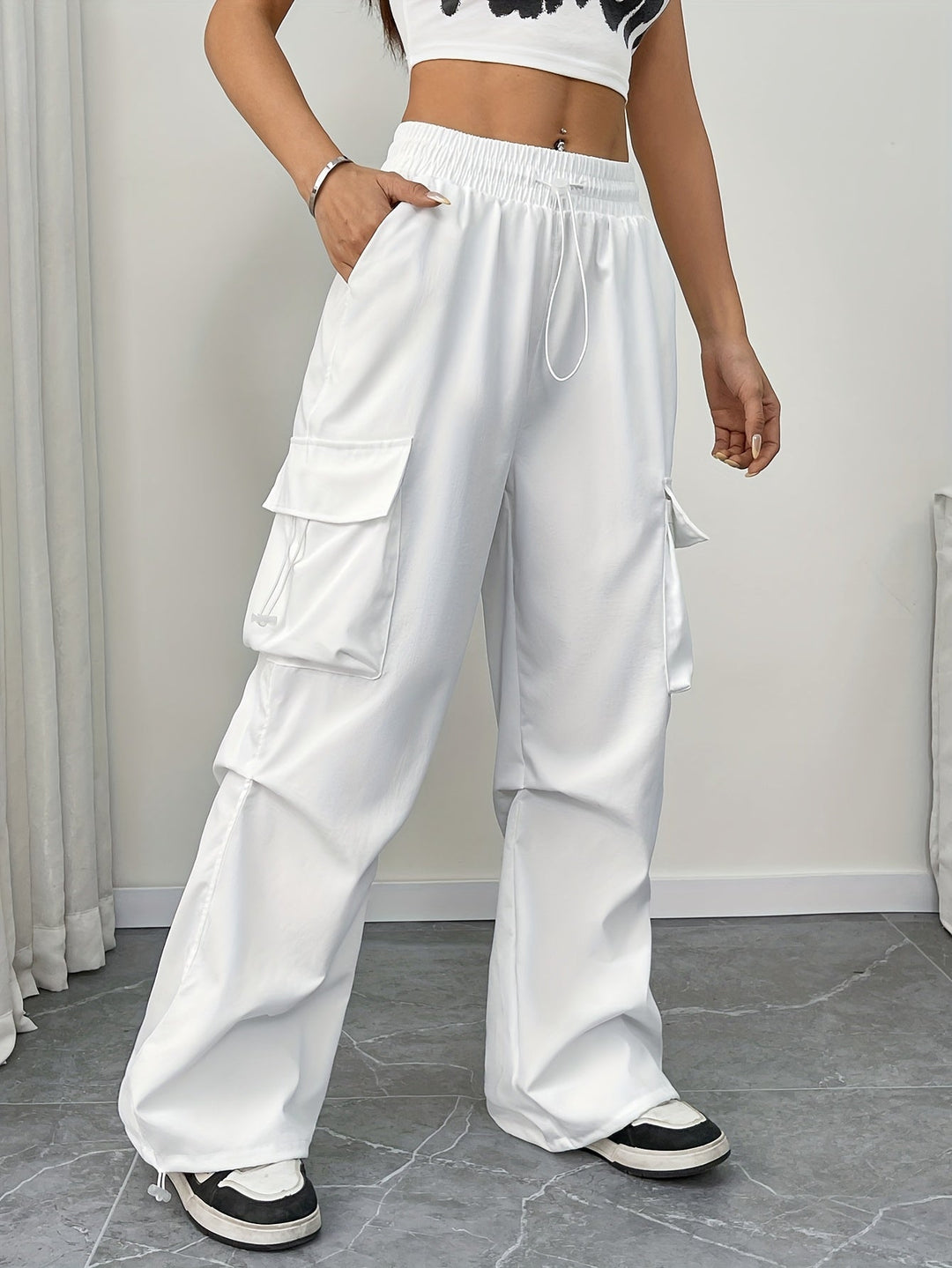 Women's wide leg cargo pants with drawstring waist. Relaxed fit, ideal for casual streetwear fashion.