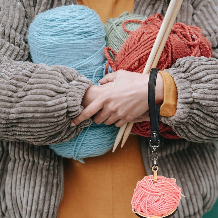 Wooden yarn holder on a crafting table, ensuring smooth yarn flow for all projects.